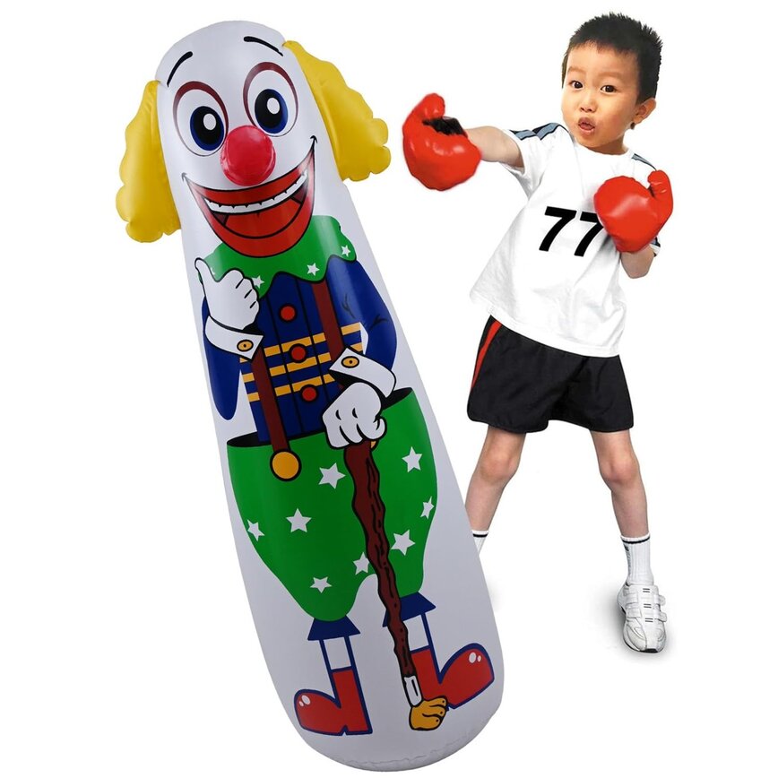 A child in boxing gloves punching an inflatable clown bop bag that keeps standing back up.
